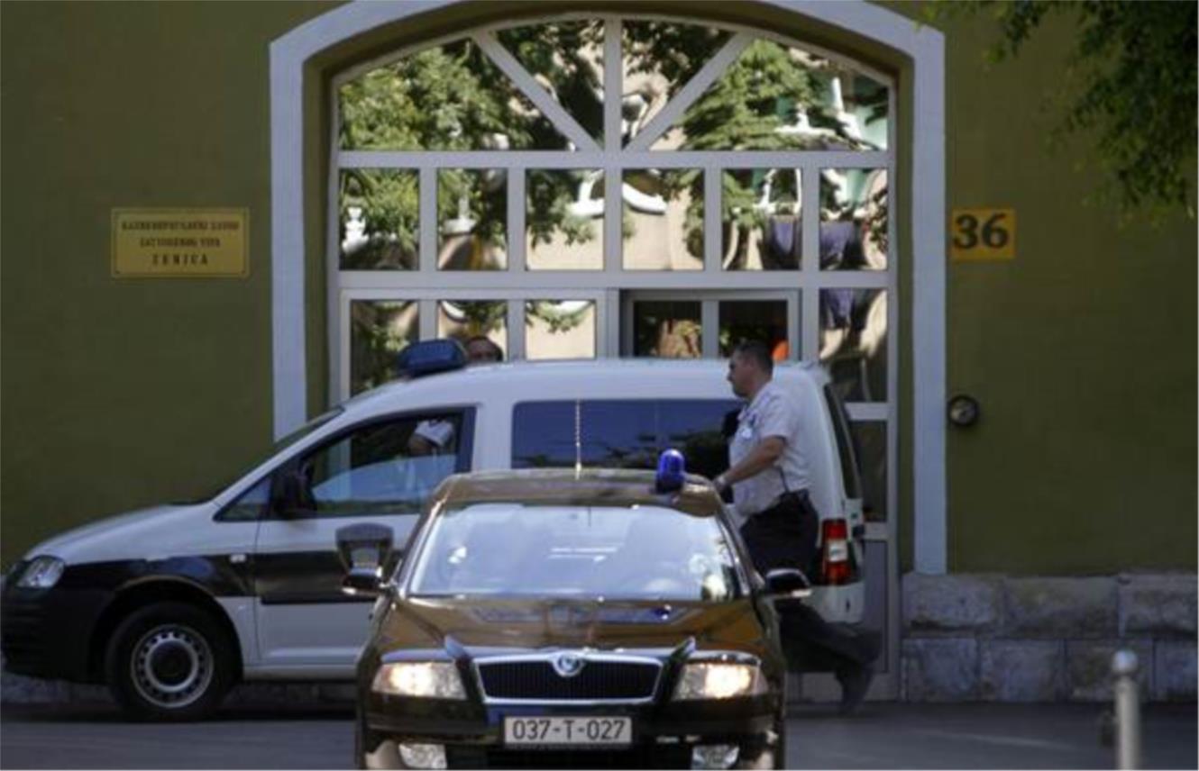 Policajci ulaze u auto prije Glavasevog transporta