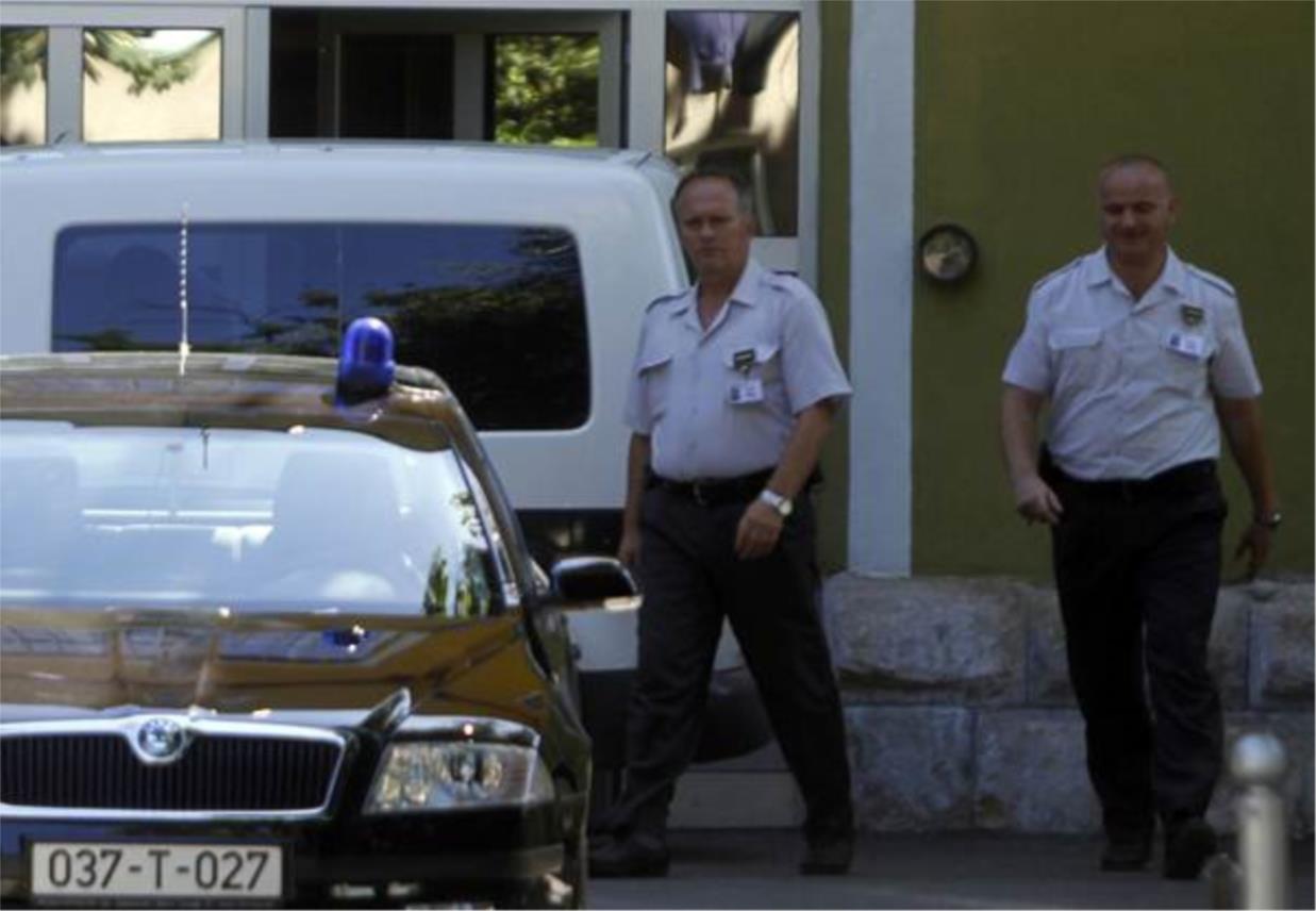 Policajci ulaze u auto prije Glavasevog transporta.